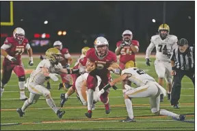  ??  ?? Jackson Keays (center) carries the ball against El Dorado.