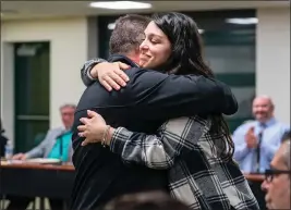  ?? PHOTOS BY THE PITTSBURGH POST-GAZETTE ?? Penn-Trafford Middle School special education teacher Alexis Simon gets a hug from Michael Cleland during a school board meeting.