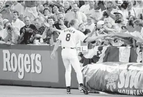  ?? BALTIMORE SUN 1995 PHOTO ?? Cal Ripken Jr. runs around the field greeting fans after breaking Lou Gehrig’s record.