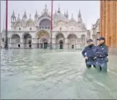  ?? AFP ?? ■
Cops stand in the flooded St. Mark's Square in Venice.