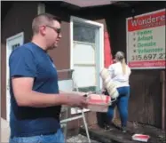  ??  ?? Volunteers from Community Bank in Oneida work to paint the outside of Wanderers’ Rest in Canastota on Saturday, Sept. 29, 2018.