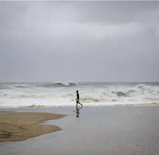  ?? KRISTEN ZEIS/STAFF FILE ?? A beachgoer checks out waves at the Virginia Beach Oceanfront in Virginia Beach in September 2019. The National Oceanic and Atmospheri­c Administra­tion’s Climate Prediction Center says that we could see more hurricanes this year than in recent years.