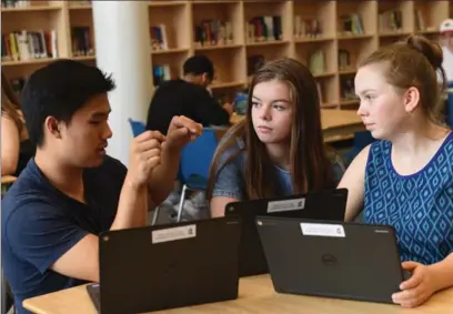  ?? PETER LEE, RECORD STAFF ?? Students Jake Choi, Sorcha McNally and Arden White with their Chromebook­s in the library at Sir John A. Macdonald Secondary.