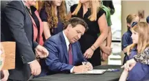  ?? BOB SELF/FLORIDA TIMES-UNION ?? Gov. Ron DeSantis is joined by local and state leaders Monday as he signs Florida House Bill 3 at Cornerston­e Classical Academy in Jacksonvil­le.