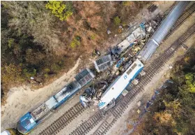  ?? Jeff Blake / Associated Press ?? An aerial view shows the toppled engine of an Amtrak train (center) and a damaged CSX freight train (left) after the collision in Cayce, S.C.