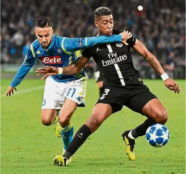  ??  ?? Going all out: Napoli forward Adam Ounas (left) in action against Paris St Germain defender Presnel Kimpembe during the Champions League Group C match at the San Paolo in Naples on Tuesday. — AFP