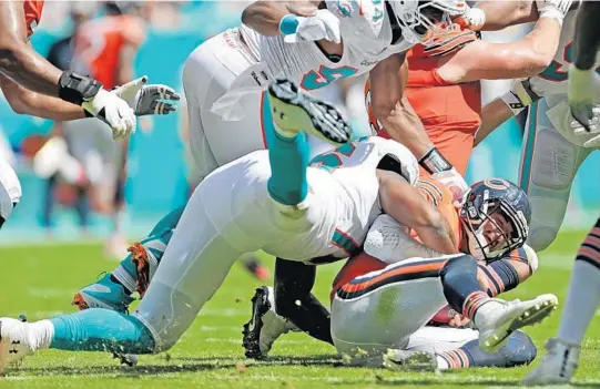  ?? JOHN MCCALL/SUN SENTINEL ?? Dolphins defensive end Jonathan Woodard sacks Bears quarterbac­k Mitchell Trubisky in the second quarter of their game at Hard Rock Stadium in Miami Gardens on Sunday.