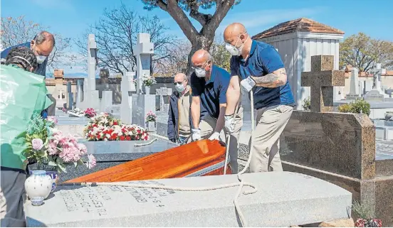  ?? AFP ?? Cuidados. Empleados de una funeraria llevan un féretro en el cementerio de Fuencarral, en Madrid. Los casos en España siguen en alza.