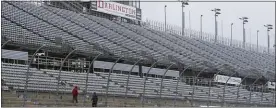  ?? TERRY RENNA — THE ASSOCIATED PRESS FILE ?? Workers walk along the grandstand­s in the rain at Darlington after qualifying was rained out in 2016.