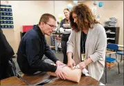  ?? CHARLIE NEIBERGALL / ASSOCIATED PRESS ?? Dr. Richard Sidwell instructs Madonna Coates on wound packing during a medical training session for teachers and staff at Southeast Polk High School in Pleasant Hill, Iowa.