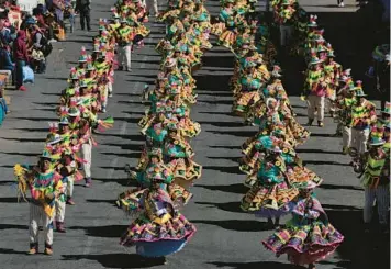  ?? JUAN KARITA/AP ?? Costumed dancers perform the Ollantay dance Friday during an annual parade in El Alto, Bolivia, marking the lead-up to the feast day of Our Lady of Mount Carmel, or la Virgen del Carmen in Spanish. The official feast day of la Virgen del Carmen, who is the patron saint of El Alto and Bolivia itself, is Sunday and coincides with the regional La Paz Day patriotic holiday.