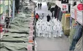  ?? Lim Hwa-young Yonhap ?? SOUTH KOREAN workers spray disinfecta­nt in a market as a precaution against coronaviru­s.