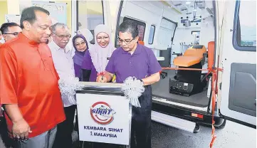  ??  ?? Hilmi signs a plaque to symbolical­ly launch the mobile dental clinic after closing the 1Malaysia Health Expedition. — Bernama photo