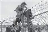  ?? SUZANNE CORDEIRO/AFP VIA GETTY IMAGES ?? A mother helps her child over the barbed wire fence in Eagle Pass, Texas, after crossing into the U.S. from Mexico on Aug. 25, 2023.