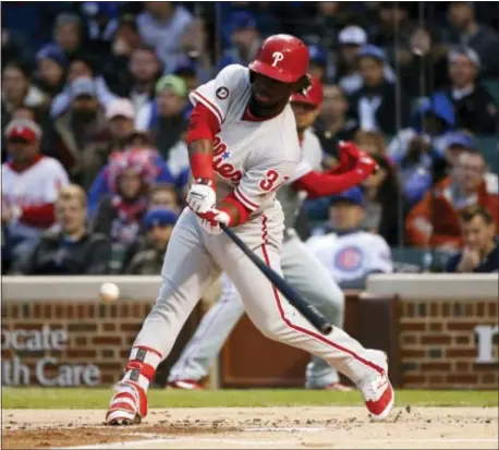  ?? CHARLES REX ARBOGAST — THE ASSOCIATED PRESS ?? Odubel Herrera steps into an RBI double off Cubs starting pitcher Jake Arrieta, driving in Maikel Franco Phillies to a first-inning lead. The Cubs rallied in the sixth and then held on for a 5-4 victory. to stake the