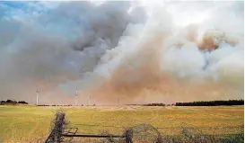  ??  ?? Heavy smoke drifts above a farm field about five miles south of Seiling on the east side of Dewey County as large wildfires ignited Tuesday afternoon.