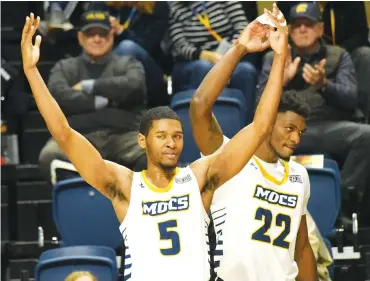  ?? STAFF PHOTO BY MATT HAMILTON ?? UTC’s Darius Banks (5) and Silvio De Sousa (22) celebrate on the sideline after the Mocs scored during Saturday’s SoCon win against The Citadel at McKenzie Arena. UTC improved to 13-3 overall and 3-0 in the conference.