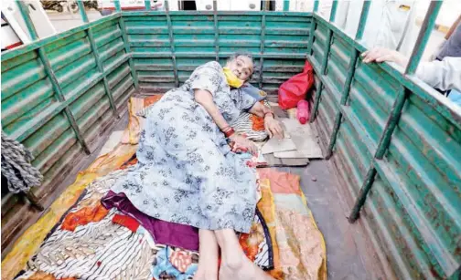  ?? Reuters ?? ↑
A woman lies in the back of a load carrier waiting to enter a hospital in Ahmedabad on Monday.