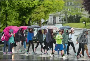  ?? DANA JENSEN/THE DAY ?? A group from Acadia Middle School in Clifton Park, N.Y., crosses the street in the rain to enter Mystic Seaport on Thursday. The group, in town just for the day, was planning on going to the Mystic Aquarium later in the day.
