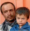  ??  ?? Ali Ahmad, 4, sits with his father as they pose for a photograph at their house after he survived a suicide attack.