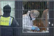  ?? (AP/dpa/Jonas Walzberg) ?? Investigat­ors and forensic experts work at the shooting scene Friday at a Jehovah’s Witness building in Hamburg, Germany.