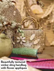  ??  ?? Beautifull­y textured wicker sling handbag with flower appliques