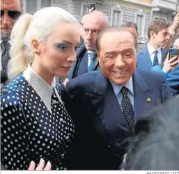  ?? MATTEO BAZZI / EFE ?? Silvio Berlusconi, líder de Forza Italia, y su novia salen del colegio electoral.