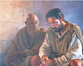  ??  ?? Luke (Jim Caviezel, right) ventures into the Roman prison to bring solace to his friend (James Faulkner) in “Paul, Apostle of Christ.” PHOTOS BY MARK CASSAR/CTMG