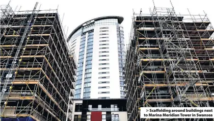  ??  ?? > Scaffoldin­g around buildings next to Marina Meridian Tower in Swansea