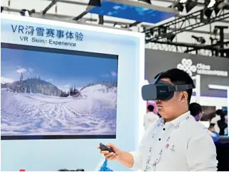  ??  ?? 18 de octubre de 2019. Un visitante en Wuzhen usa gafas 5G VR para experiment­ar el esquí.