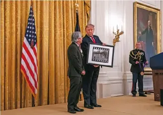  ??  ?? Ut, con Trump en la ceremonia de premiación en la Casa Blanca, donde el expresiden­te
mostró su copia firmada de la icónica imagen de la “niña del napalm”.