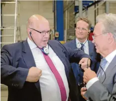  ?? Foto: dpa ?? Minister Peter Altmaier (links) besucht mehrere Unternehme­n – hier steht er neben Goldbeck-Gründer Ortwin Goldbeck. Hilft das der Wirtschaft?