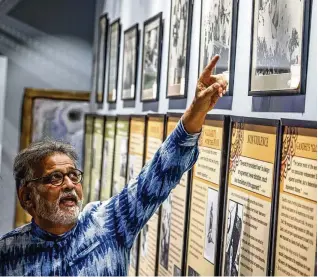  ?? JIM NOELKER / STAFF ?? Tushar Arun Gandhi from Mumbai, India, the great-grandson of Mahatma Gandhi, was at the Internatio­nal Peace Museum in Dayton on Friday. Gandhi points out photos of his great-grandfathe­r that hang in the museum.