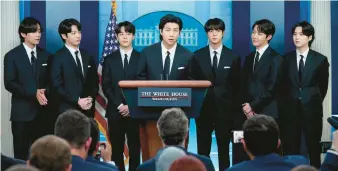  ?? EVAN VUCCI/AP ?? BTS member RM, center, speaks at the White House on Tuesday. Accompanyi­ng him are the band’s other members V, from left, Jungkook, Jimin, Jin, J-Hope and Suga.