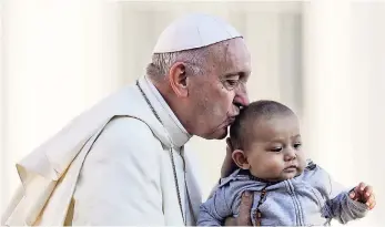  ?? AP ?? Pope Francis kisses a child as he arrives with the popemobile in St Peter’s Square to hold his weekly general audience at the Vatican, Wednesday, October 10.