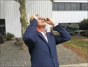 ?? VIKTORIA SUNDQVIST / HEARST CONNECTICU­T MEDIA ?? Connecticu­t Gov. Dannel Malloy uses special glasses to look at the solar eclipse Monday outside the New Haven Register building in New Haven.