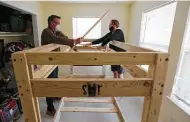  ??  ?? Shane Arnold and his son Gavin, 15, install a bunk bed from Sleep in Heavenly Peace at Jessica Cabot’s home.