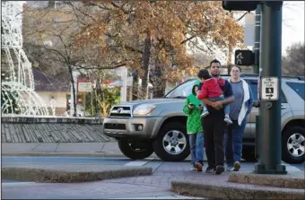  ?? The Sentinel-Record/Grace Brown ?? CROSSWALK CRACKDOWN: An unidentifi­ed family walks on the marked crosswalk at the intersecti­on of Central Avenue and Reserve Street Wednesday afternoon. Hot Springs police plan to increase enforcemen­t of crosswalks in the city and traffic downtown over the next few days due to the holiday crowds and an injury carriage crash downtown over the weekend.