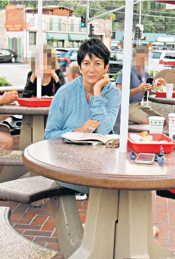  ??  ?? Ghislaine Maxwell reads a book about the CIA after tucking into a meal at the In-n-out burger bar in Los Angeles on Monday