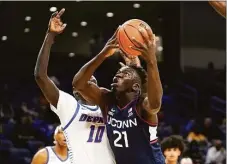  ?? Charles Rex Arbogast / Associated Press ?? UConn’s Adama Sanogo (21) looks to the basket as DePaul’s Yor Anei defends during the first half on Jan. 29 in Chicago.