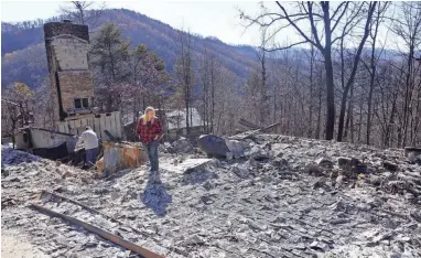  ?? ASSOCIATED PRESS ?? Tammy Sherrod and her husband, Scott, examine the remains of their home in the Roaring Fork neighborho­od of Gatlinburg.