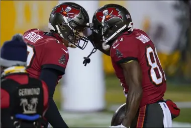  ?? JULIO CORTEZ - THE ASSOCIATED PRESS ?? Tampa Bay Buccaneers quarterbac­k Tom Brady (12) and wide receiver Antonio Brown (81) celebrate a touchdown pass during the first half of an NFL wild-card playoff football game against the Washington Football Team, Saturday, Jan. 9, 2021, in Landover, Md.