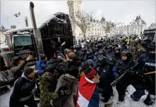  ?? COLE BURSTON /THE CANADIAN PRESS ?? Police clear downtown Ottawa near Parliament Hill of protesters on Saturday. Police resumed pushing back protesters on Saturday after arresting more than 100 and towing away vehicles in Canada’s besieged capital.