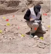  ?? AFP ?? A forensic expert works at a mass grave near Najaf on Saturday.