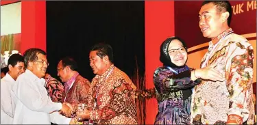  ?? DOK/KEMEN PAN-RB ?? CEKATAN: Tri Rismaharin­i dan Wali Kota Malang M. Anton antre penghargaa­n inovasi dari Wapres Jusuf Kalla dan Menteri PAN-RB Yuddy Chrisnandi.