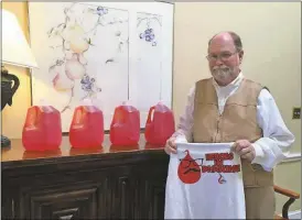  ?? Contribute­d photo ?? William Summer, who is two pints away from his fifth gallon of blood, shows what four gallons of colored water look like to give an idea about the volume of his donations since 2001.