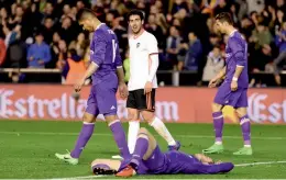  ?? — AFP ?? Real Madrid’s Casemiro (left), Gareth Bale (on the ground) and Cristiano Ronaldo (right) react after their 1-2 defeat to Valencia in their La Liga match at the Mestalla Stadium in Valencia on Wednesday.