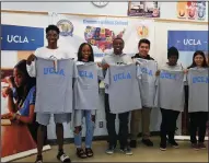  ?? RICK LOOMIS/LOS ANGELES TIMES ?? Seven prospectiv­e UCLA students from Crenshaw High in Los Angeles hold up t-shirts during a recruiting event on April 6. Applicatio­ns to the UC system hit record highs for the 13th year in a row.