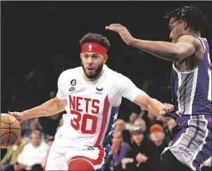  ?? SARAH STIER/GETTY IMAGES ?? The Nets’ Seth Curry (30) drives against the Kings’ Davion Mitchell on Thursday in New York.