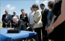  ?? JULIO CORTEZ — THE ASSOCIATED PRESS ?? Lawmakers stand by as New Jersey Gov. Phil Murphy, center, signs a bill banning smoking on parks and beaches on the boardwalk in Long Branch, N.J., Friday. Fines would start at $250 for a first offense and go up to $1,000 for a third offense for people smoking out of designated areas.